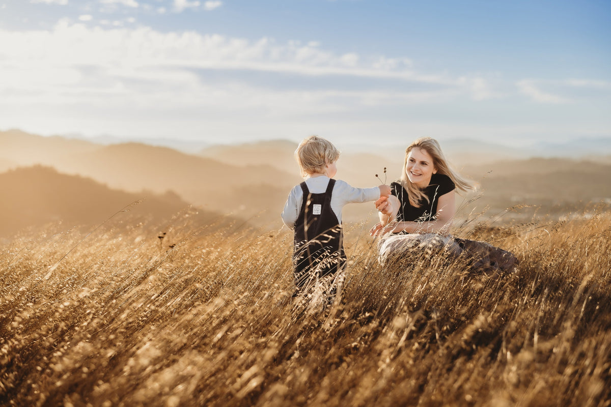 A mother and child in a golden field at sunset