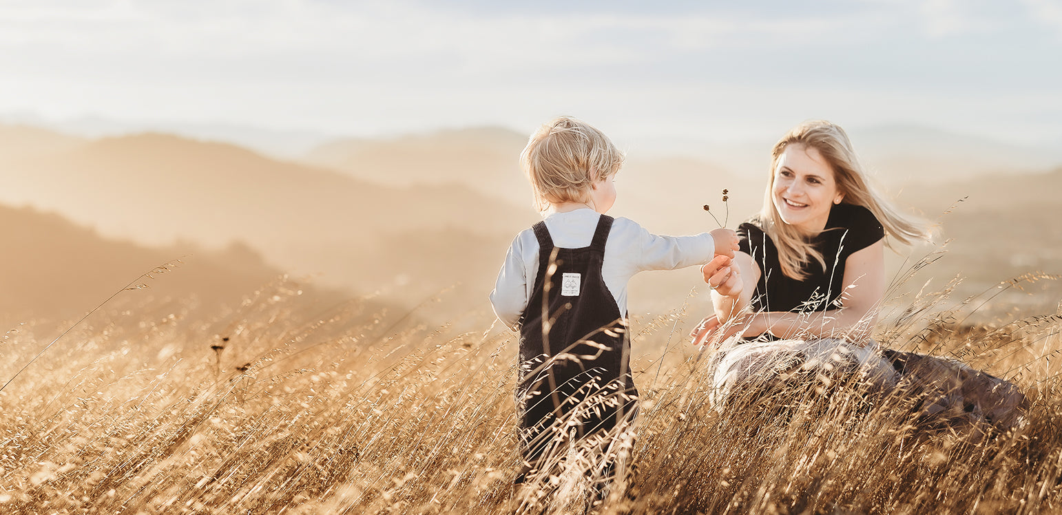 Woman and child in a field with a scenic background